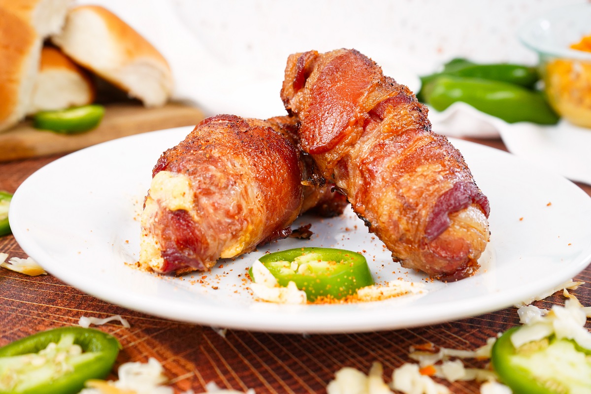 Armadillo eggs wrapped in bacon on plate. 